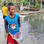 Banjir Pegangsaan Dua: Anak-anak Tangkap Ikan Mujaer untuk Lauk Gorengan
