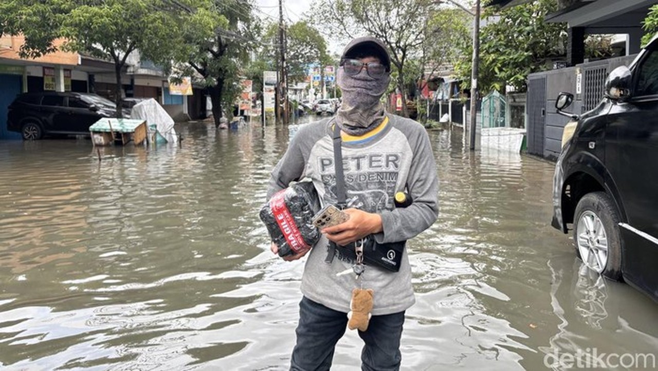 Kurir Candra Terjang Banjir Bekasi: Demi Paket Sampai, Rela Jalan Kaki di Tengah Ketinggian Air Sepinggang